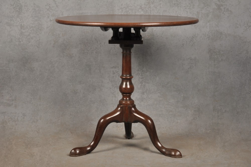An 18th-century mahogany tripod table featuring a circular top, a central turned baluster pedestal, and three cabriole legs terminating in pad feet. View III