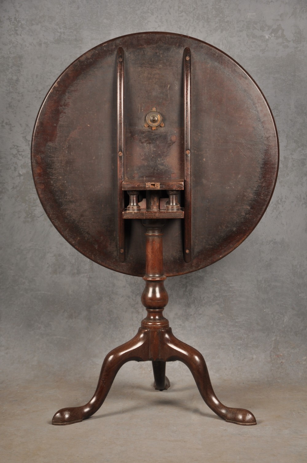 An 18th-century mahogany tripod table featuring a circular top, a central turned baluster pedestal, and three cabriole legs terminating in pad feet. View IV