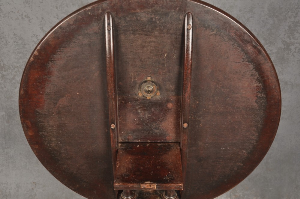 An 18th-century mahogany tripod table featuring a circular top, a central turned baluster pedestal, and three cabriole legs terminating in pad feet. View V
