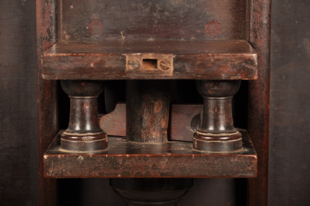 An 18th-century mahogany tripod table featuring a circular top, a central turned baluster pedestal, and three cabriole legs terminating in pad feet. View VI