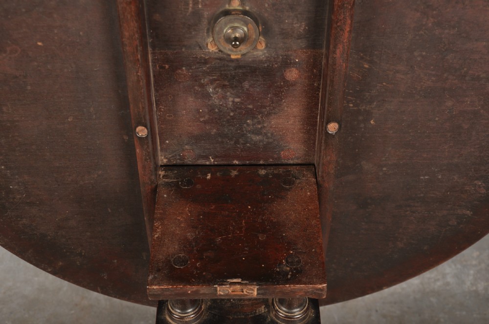 An 18th-century mahogany tripod table featuring a circular top, a central turned baluster pedestal, and three cabriole legs terminating in pad feet. View VIII