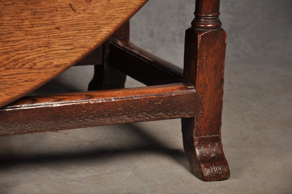A large 18th-century oak gateleg table shown with one semi-circular drop leaf folded down and turned legs resting on rectangular stretchers. View VII