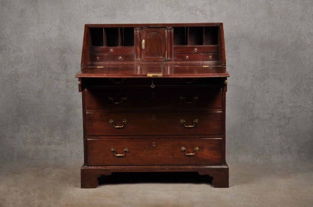 An eighteenth-century mahogany slant-front writing bureau featuring four graduated drawers with brass swan-neck handles and bracket feet. View II