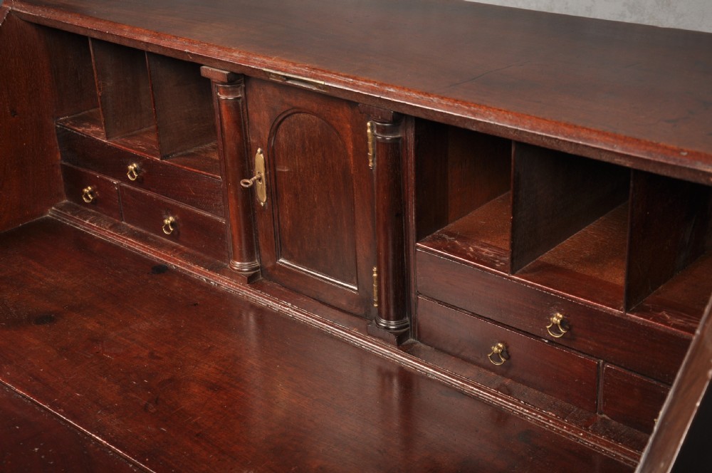An eighteenth-century mahogany slant-front writing bureau featuring four graduated drawers with brass swan-neck handles and bracket feet. View III