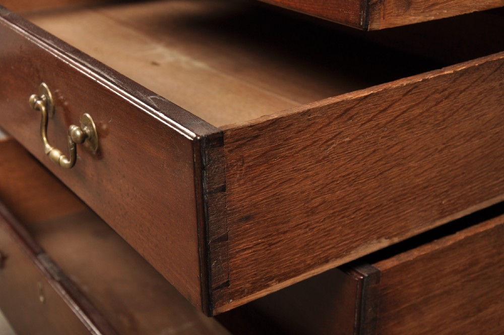An eighteenth-century mahogany slant-front writing bureau featuring four graduated drawers with brass swan-neck handles and bracket feet. View XV