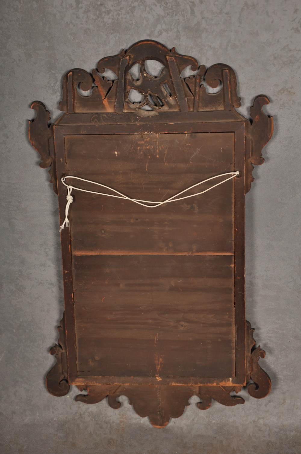An 18th-century Chippendale mahogany wall mirror featuring a scrollwork fretwork frame, an inner gilt slip, and a carved gilt phoenix motif atop the cresting. View IV