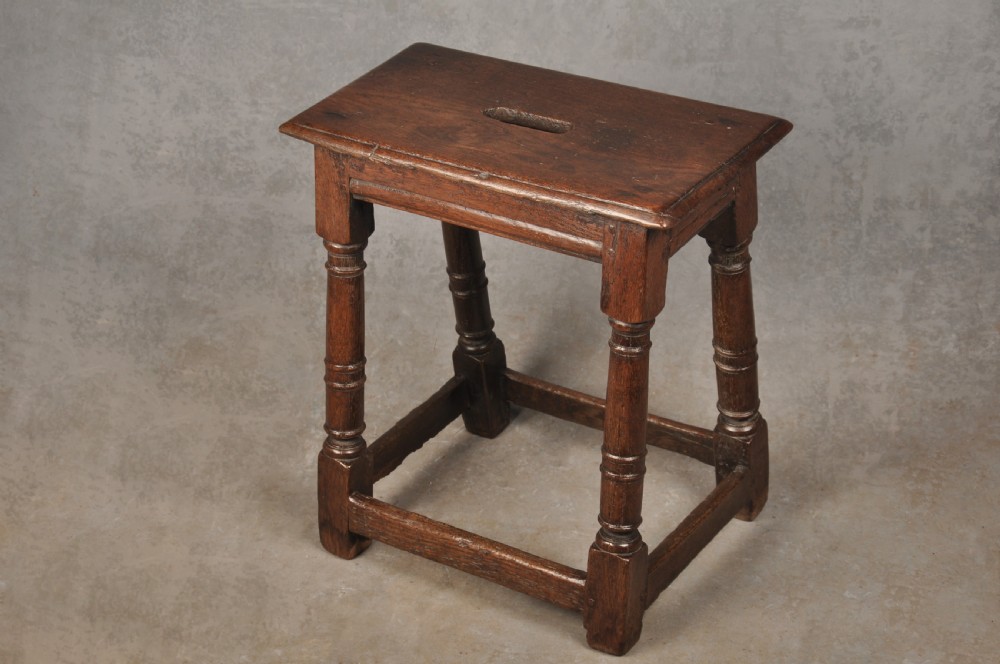 A 17th-century oak joint stool with turned legs, mortise-and-tenon peg construction, and lower perimeter stretchers. View II