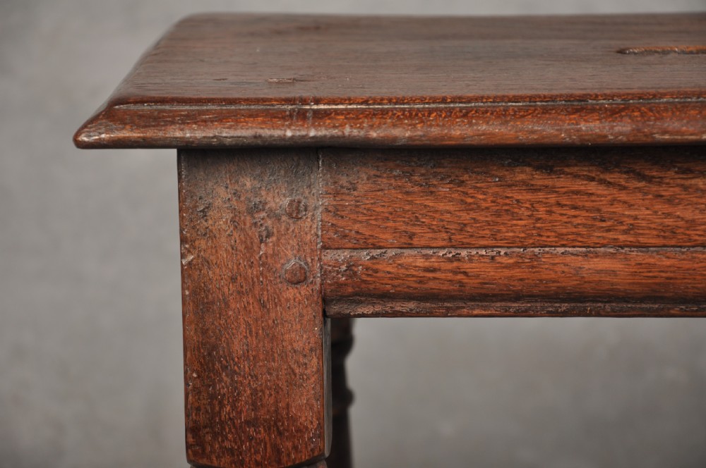 A 17th-century oak joint stool with turned legs, mortise-and-tenon peg construction, and lower perimeter stretchers. View IV