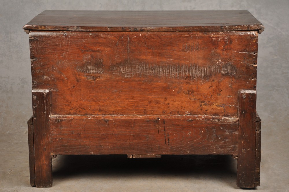 An 18th-century dark oak coffer bach with a hinged lid, three front panels, two lower drawers, and brass handles. View XIV