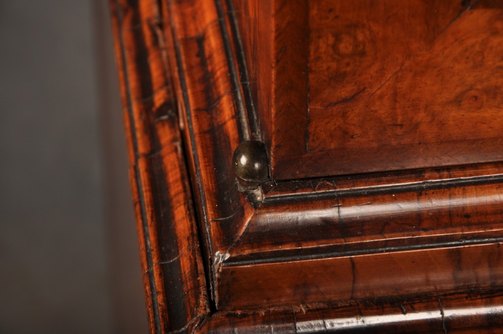 An early eighteenth-century burr walnut secretaire cabinet featuring double upper doors and a lower chest of drawers with brass handles. View VI