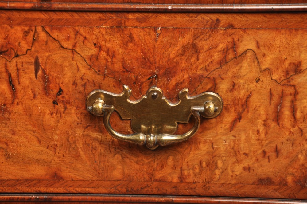 An early eighteenth-century burr walnut secretaire cabinet featuring double upper doors and a lower chest of drawers with brass handles. View XI