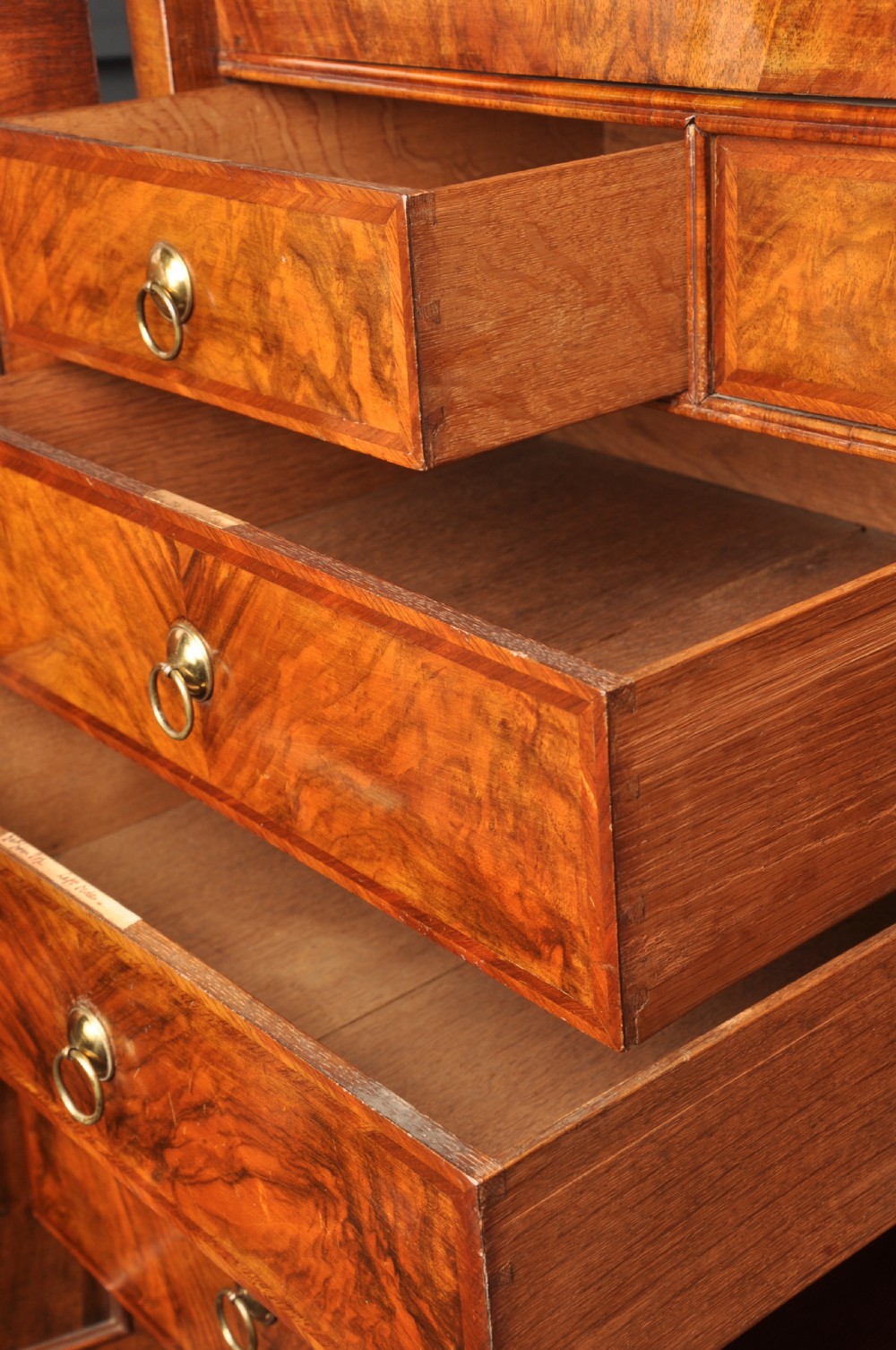 An early eighteenth-century burr walnut secretaire cabinet featuring double upper doors and a lower chest of drawers with brass handles. View XIII