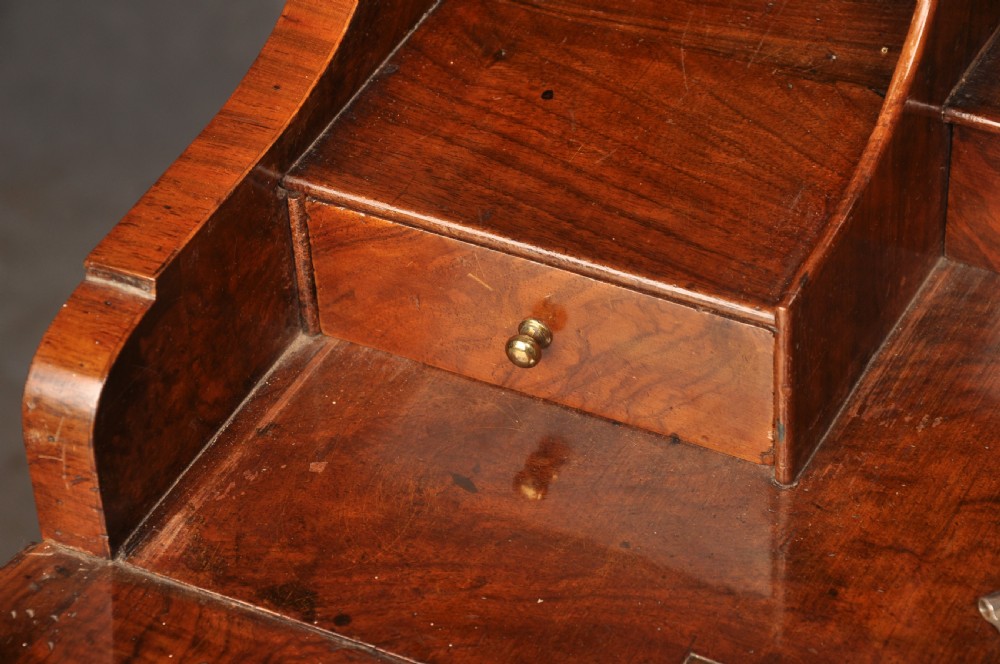 An early eighteenth-century burr walnut secretaire cabinet featuring double upper doors and a lower chest of drawers with brass handles. View XX