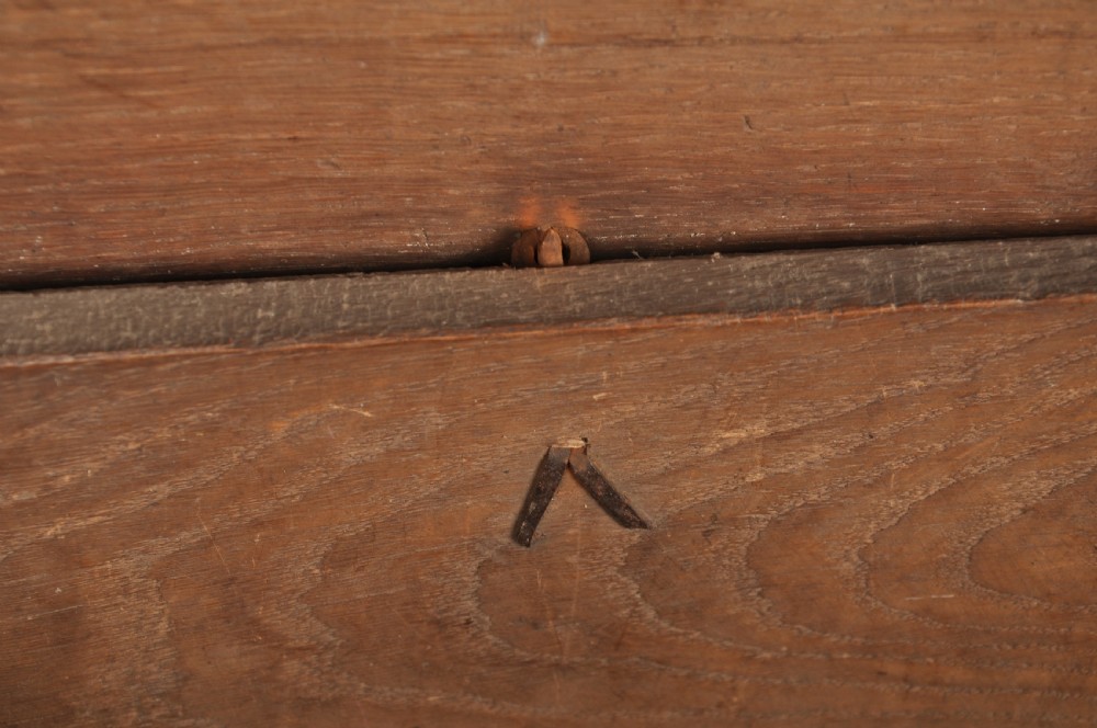 A small 17th century dark oak coffer featuring a flat hinged lid, carved lunette motifs across the front panel, and an iron lock plate. View XI