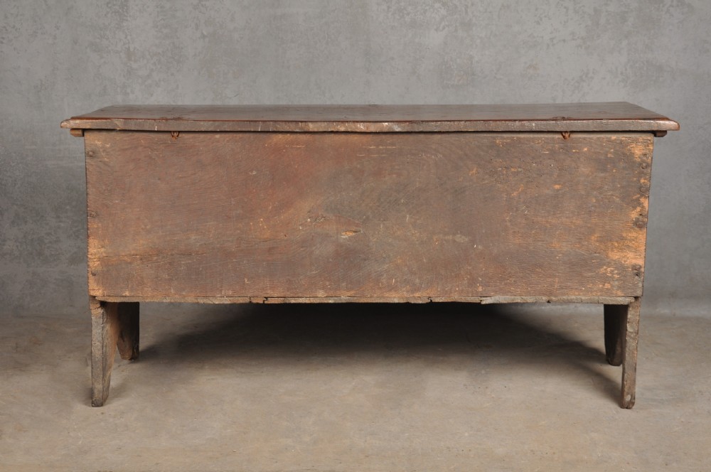 A small 17th century dark oak coffer featuring a flat hinged lid, carved lunette motifs across the front panel, and an iron lock plate. View XIII