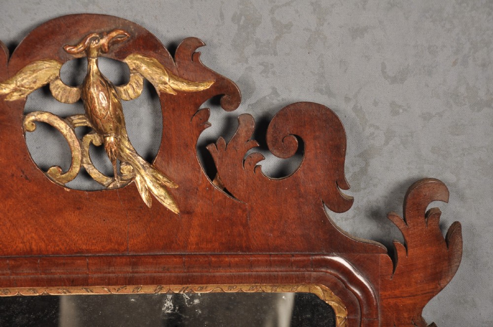 An 18th-century Chippendale style wall mirror featuring a fretwork mahogany frame, a gilded inner moulding, and a gilt phoenix crest at the top. View III