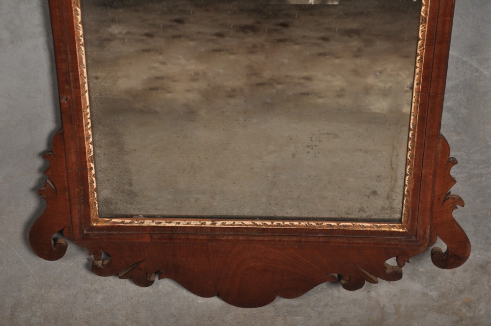 An 18th-century Chippendale style wall mirror featuring a fretwork mahogany frame, a gilded inner moulding, and a gilt phoenix crest at the top. View IV