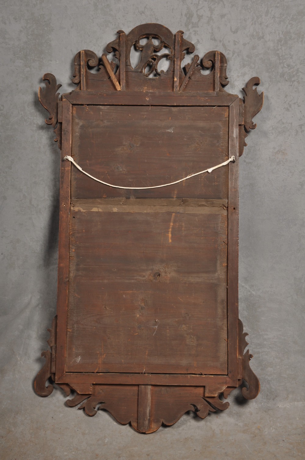 An 18th-century Chippendale style wall mirror featuring a fretwork mahogany frame, a gilded inner moulding, and a gilt phoenix crest at the top. View V
