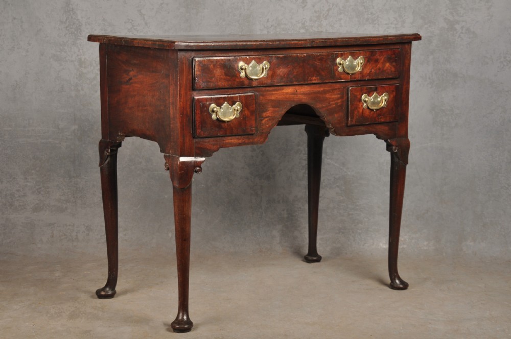 An 18th-century George II mahogany lowboy with three drawers, brass handles, a central arch apron, and four cabriole legs ending in pad feet. View III