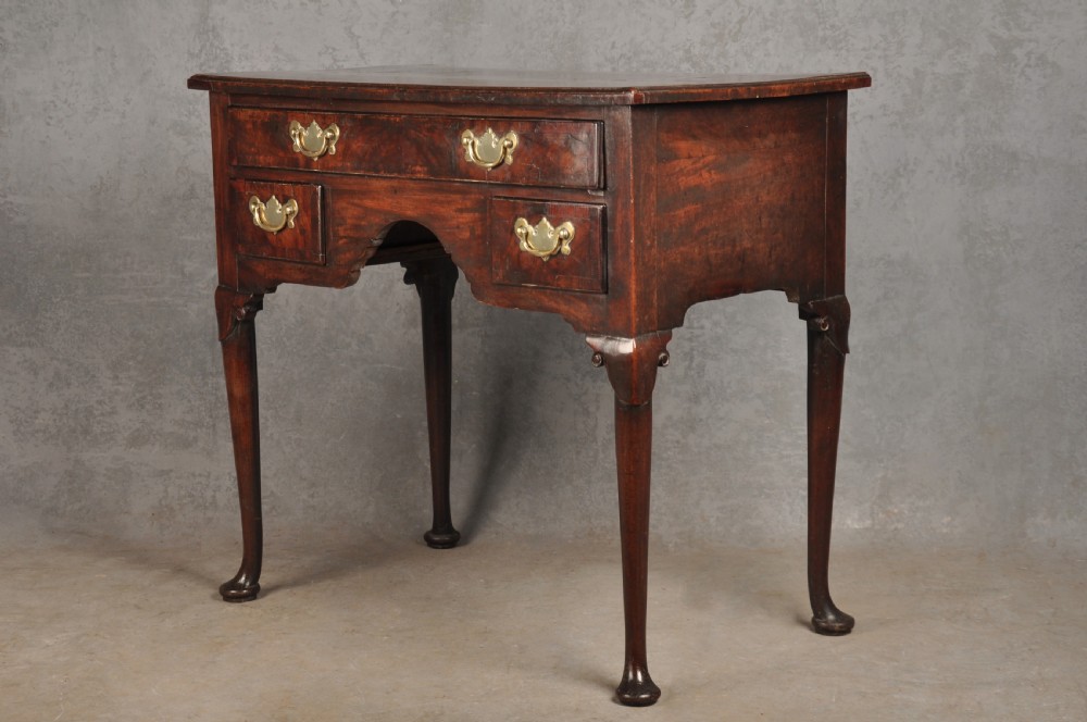 An 18th-century George II mahogany lowboy with three drawers, brass handles, a central arch apron, and four cabriole legs ending in pad feet. View IV