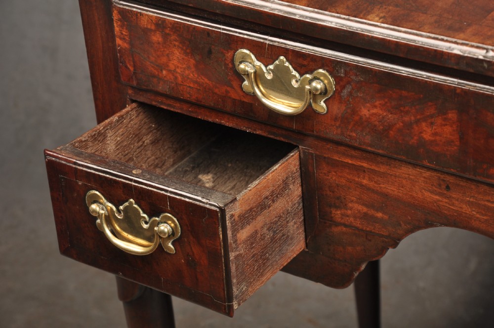 An 18th-century George II mahogany lowboy with three drawers, brass handles, a central arch apron, and four cabriole legs ending in pad feet. View IX