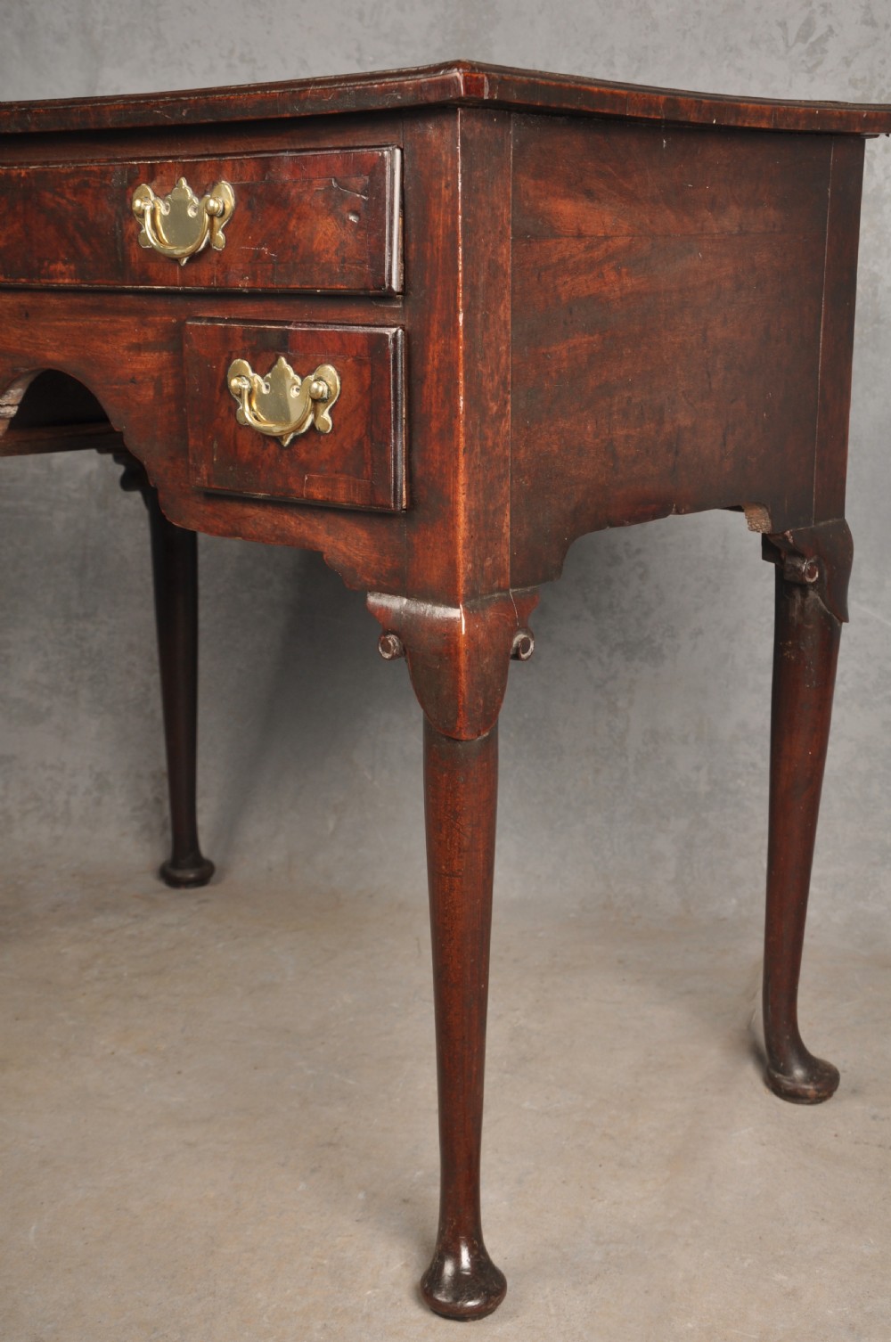 An 18th-century George II mahogany lowboy with three drawers, brass handles, a central arch apron, and four cabriole legs ending in pad feet. View XI