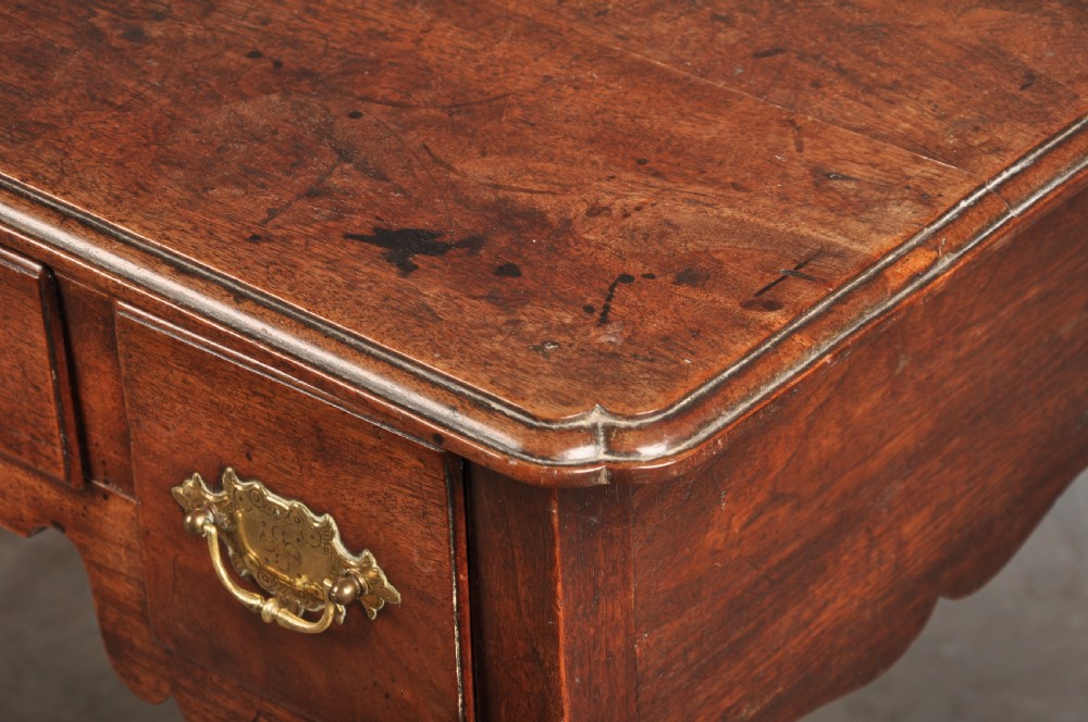 An early 18th-century walnut lowboy side table featuring three drawers with brass handles, a shaped apron, and four cabriole legs. View VI