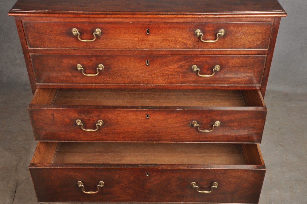 An 18th-century Georgian mahogany chest featuring four graduated drawers with brass swan-neck handles and bracket feet. View VI