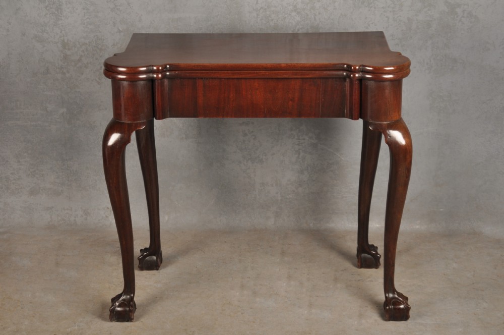 An 18th-century Georgian mahogany fold-over tea table featuring cabriole legs terminating in hand-carved ball and claw feet. View II