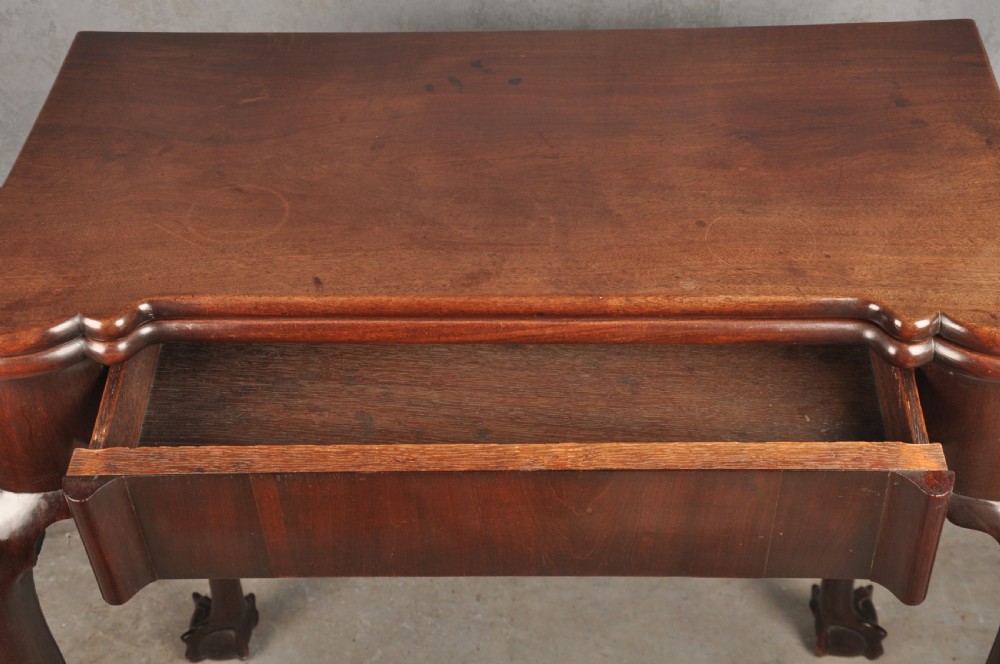 An 18th-century Georgian mahogany fold-over tea table featuring cabriole legs terminating in hand-carved ball and claw feet. View III