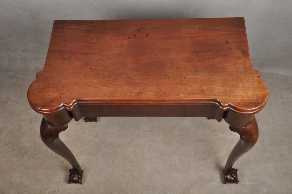 An 18th-century Georgian mahogany fold-over tea table featuring cabriole legs terminating in hand-carved ball and claw feet. View VIII