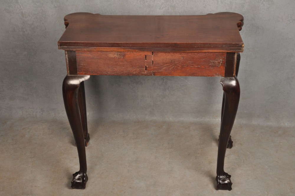 An 18th-century Georgian mahogany fold-over tea table featuring cabriole legs terminating in hand-carved ball and claw feet. View XIII