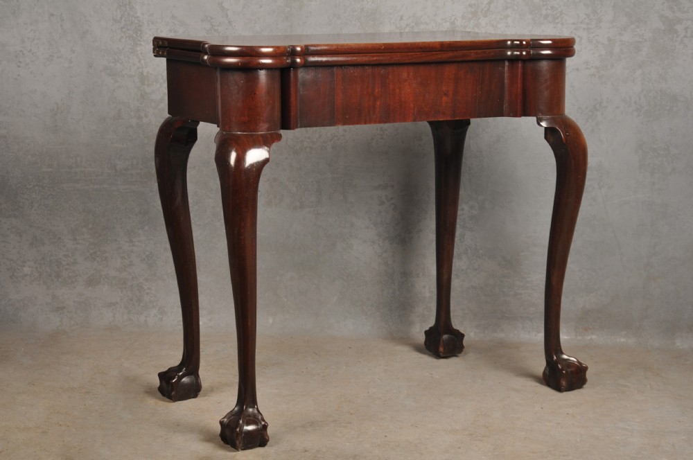 An 18th-century Georgian mahogany fold-over tea table featuring cabriole legs terminating in hand-carved ball and claw feet. View XV
