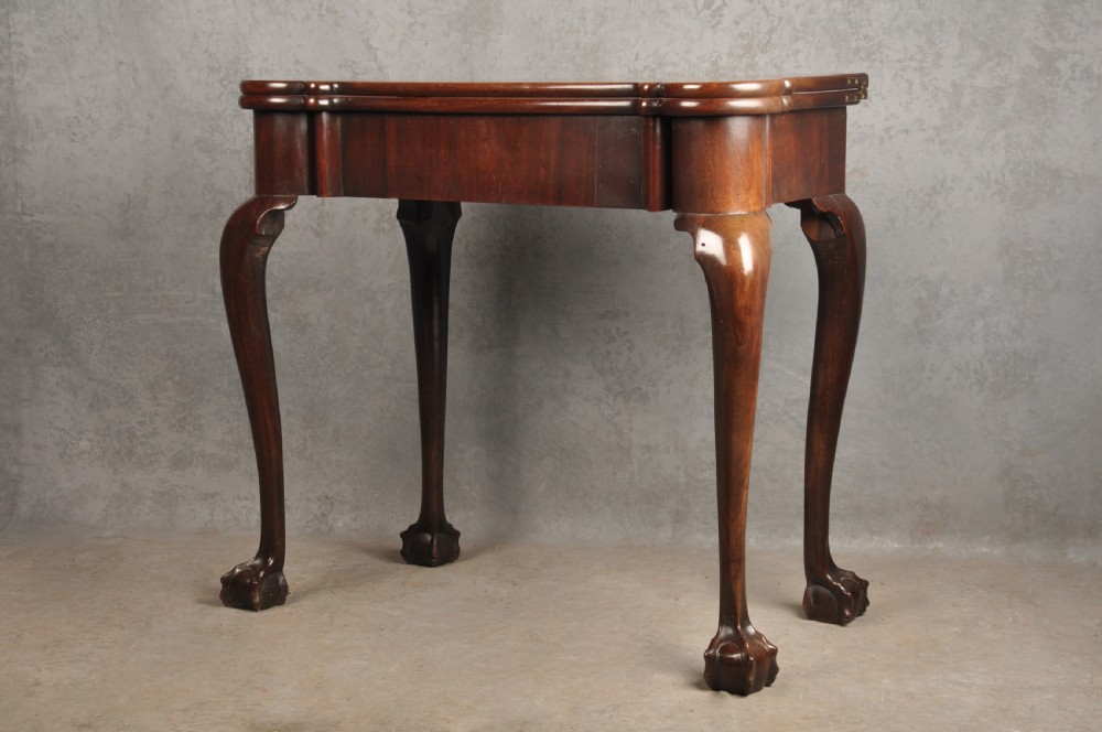 An 18th-century Georgian mahogany fold-over tea table featuring cabriole legs terminating in hand-carved ball and claw feet. View XVI