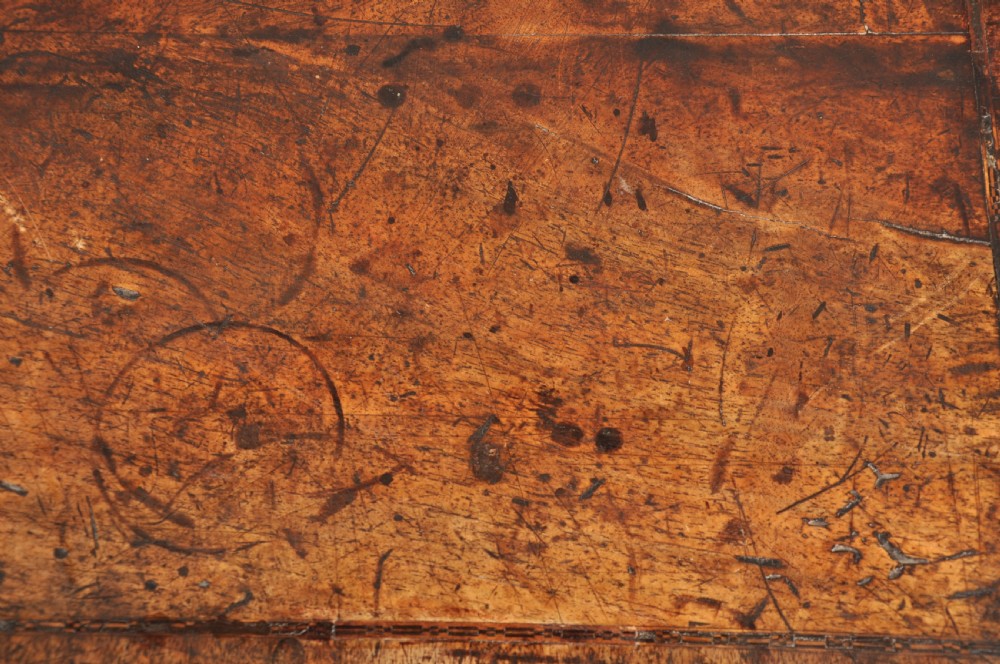 An early 18th-century walnut kneehole desk featuring crossbanded drawer fronts, brass drop handles, a central recessed cupboard, and turned bun feet. View III