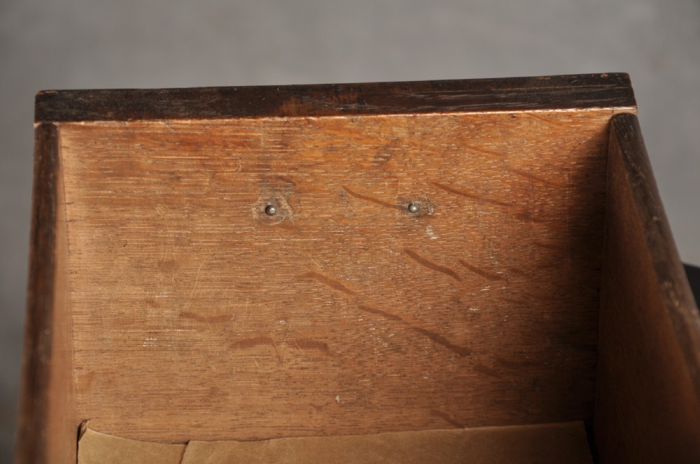 An early 18th-century walnut kneehole desk featuring crossbanded drawer fronts, brass drop handles, a central recessed cupboard, and turned bun feet. View XXII