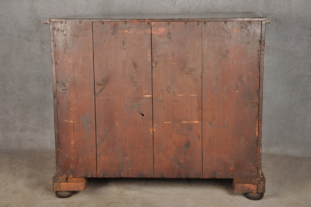 An early 18th-century walnut kneehole desk featuring crossbanded drawer fronts, brass drop handles, a central recessed cupboard, and turned bun feet. View XXIII