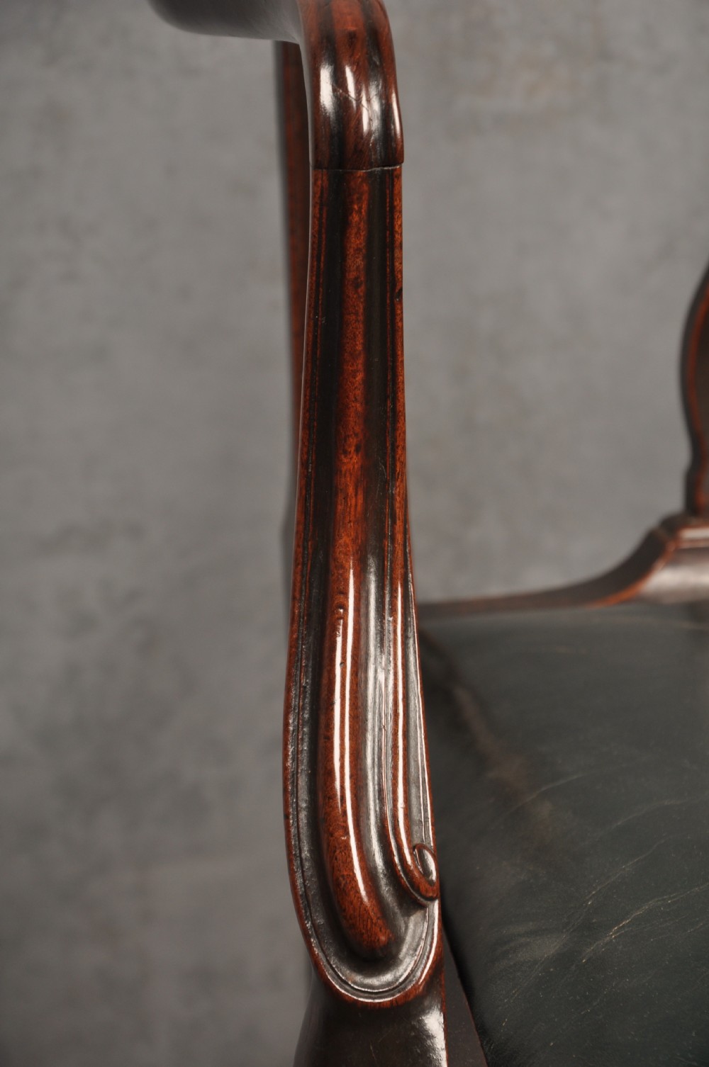 A set of eight 18th-century mahogany Hepplewhite dining chairs featuring pierced splat backrests, serpentine crest rails, square legs with stretchers, and dark green leather drop-in seats. View VI