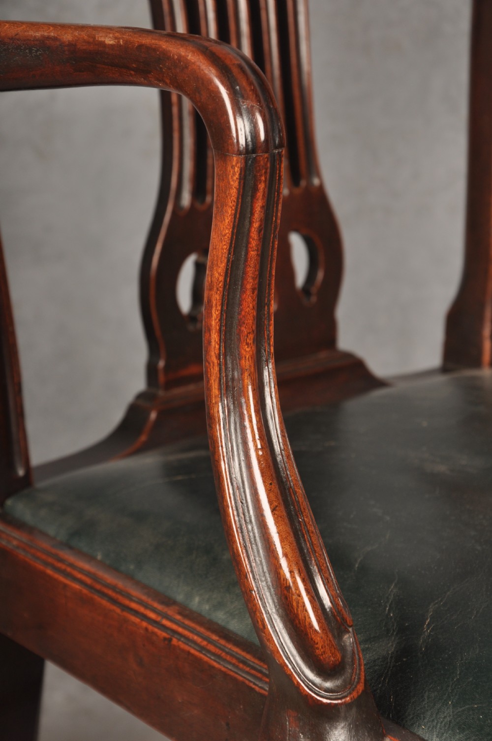 A set of eight 18th-century mahogany Hepplewhite dining chairs featuring pierced splat backrests, serpentine crest rails, square legs with stretchers, and dark green leather drop-in seats. View VII