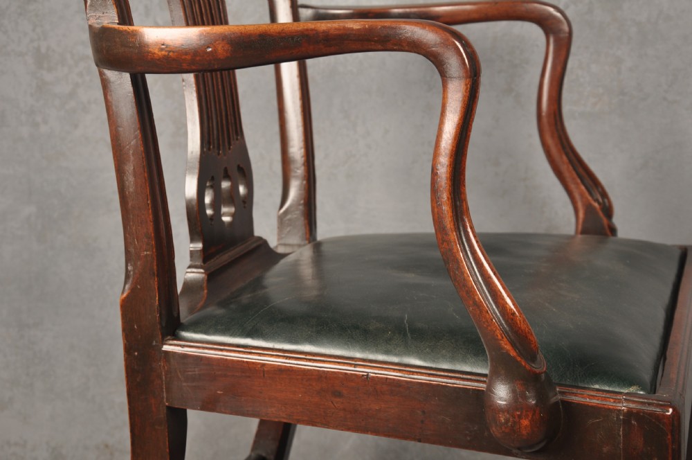 A set of eight 18th-century mahogany Hepplewhite dining chairs featuring pierced splat backrests, serpentine crest rails, square legs with stretchers, and dark green leather drop-in seats. View IX