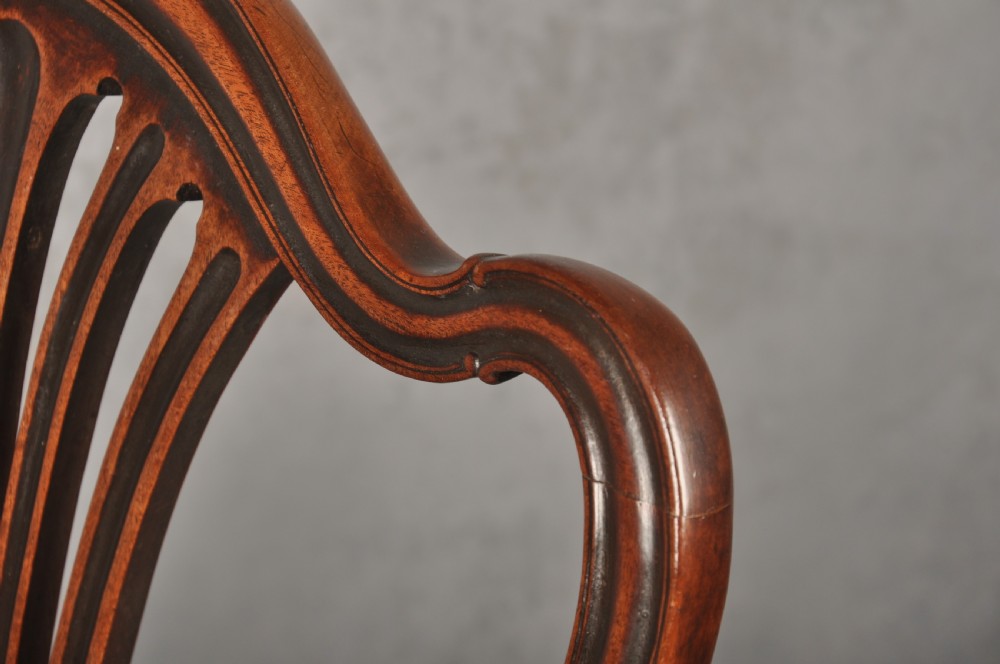 A set of eight 18th-century mahogany Hepplewhite dining chairs featuring pierced splat backrests, serpentine crest rails, square legs with stretchers, and dark green leather drop-in seats. View XIII