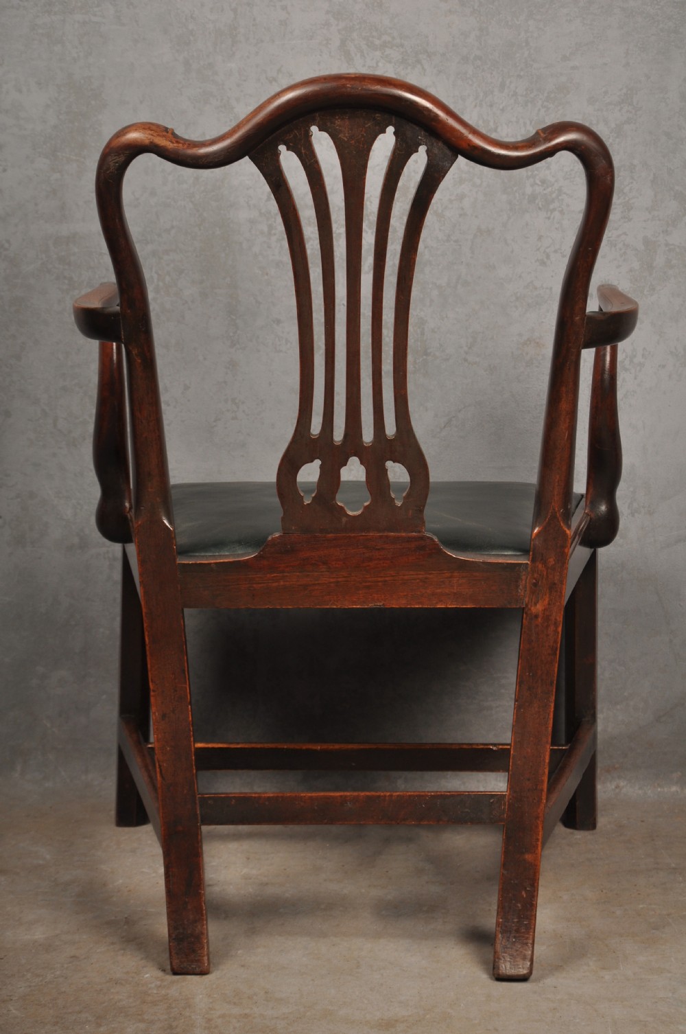 A set of eight 18th-century mahogany Hepplewhite dining chairs featuring pierced splat backrests, serpentine crest rails, square legs with stretchers, and dark green leather drop-in seats. View XV