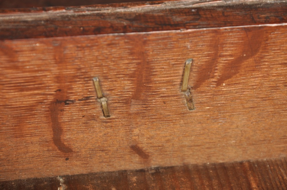 An early eighteenth-century oak lowboy side table featuring three drawers with brass handles, a shaped apron, and four cabriole legs with pad feet. View X