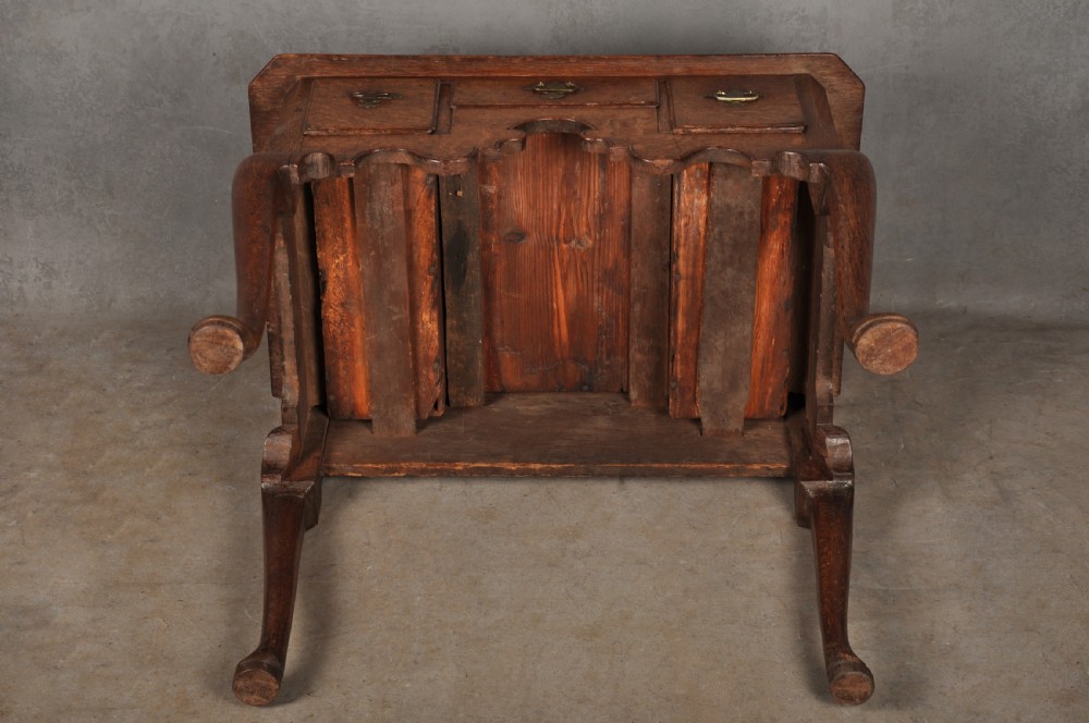 An early eighteenth-century oak lowboy side table featuring three drawers with brass handles, a shaped apron, and four cabriole legs with pad feet. View XI