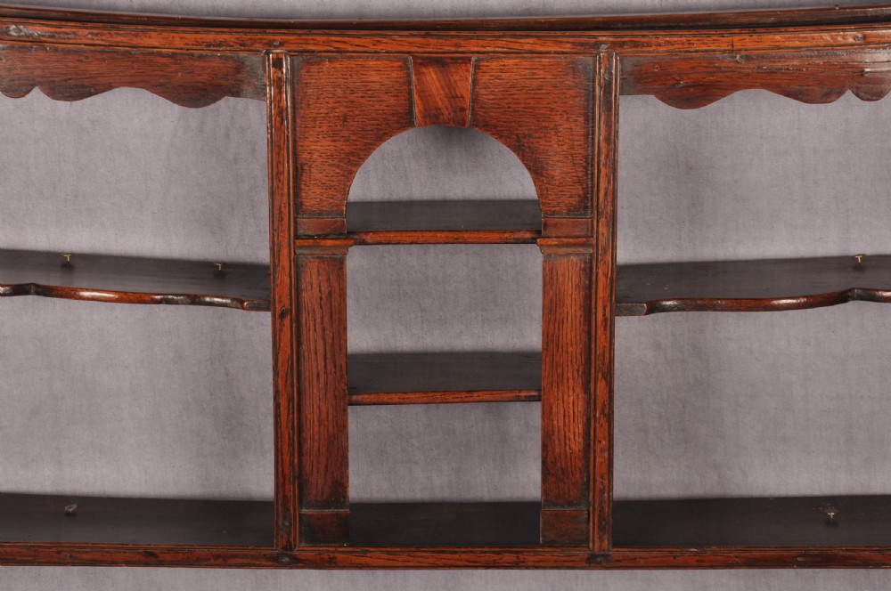 An eighteenth-century dark oak delft rack featuring open shelves, a central arched niche, and a moulded top cornice. View II