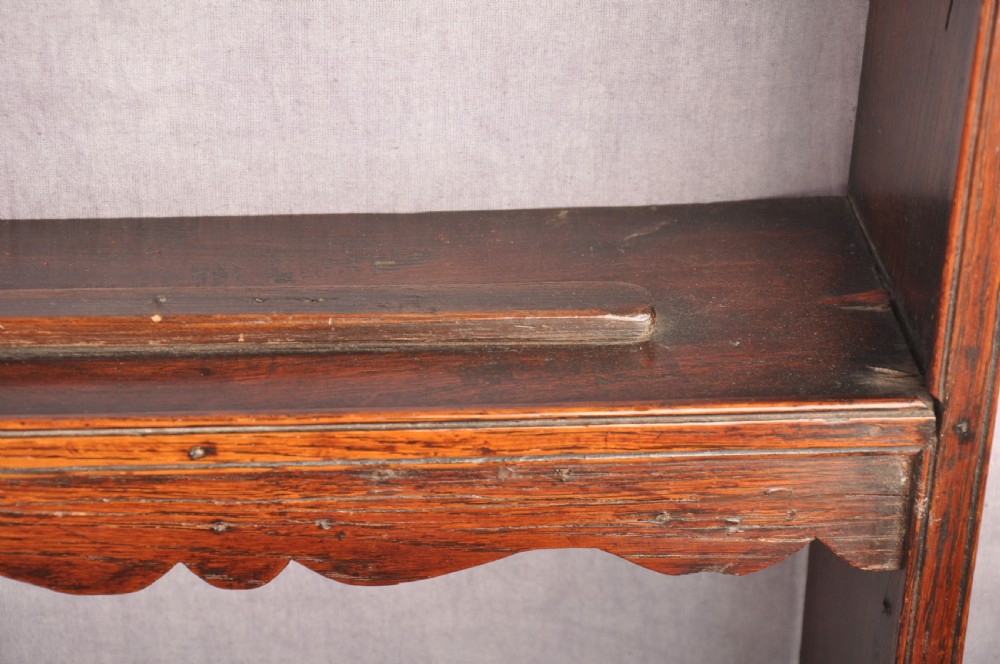 An eighteenth-century dark oak delft rack featuring open shelves, a central arched niche, and a moulded top cornice. View V