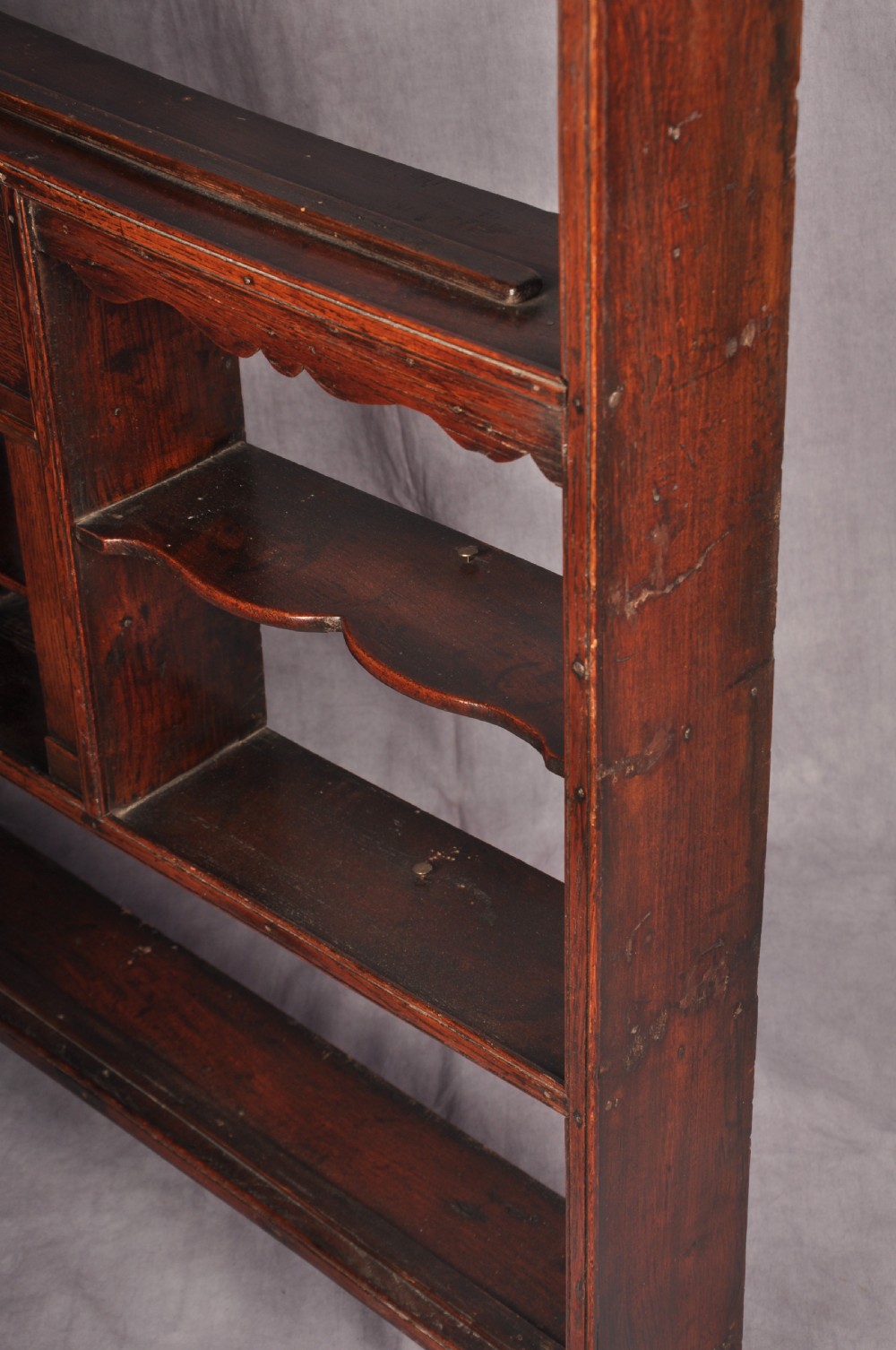 An eighteenth-century dark oak delft rack featuring open shelves, a central arched niche, and a moulded top cornice. View X