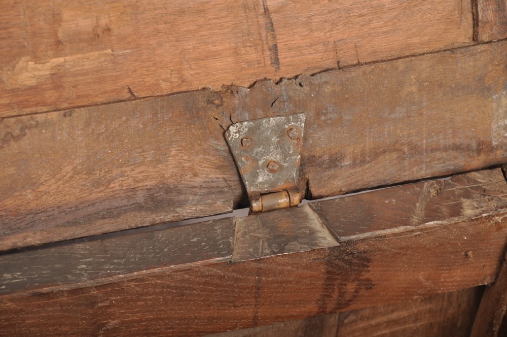 A seventeenth-century dark oak coffer featuring four carved front panels with scroll motifs, a carved top rail dated 1692 with initials DW, and a hinged lid. View XIV