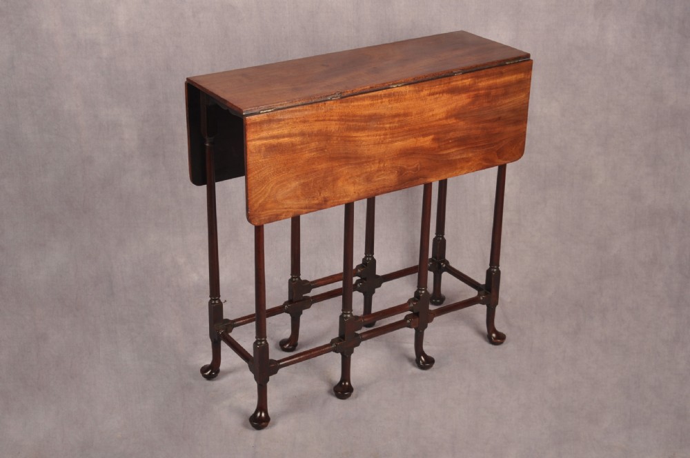 An eighteenth-century mahogany drop-leaf spider table featuring slender turned legs, cross stretchers, and pad feet.