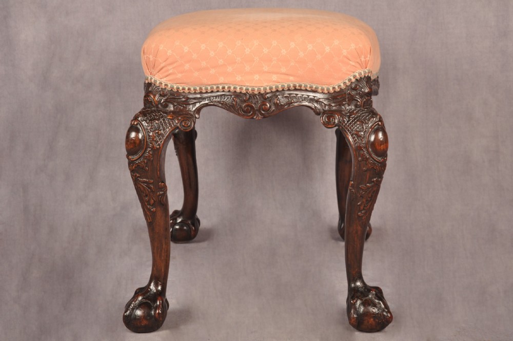 A 19th-century carved walnut stool featuring cabriole legs with claw-and-ball feet and a peach patterned upholstered top. View III